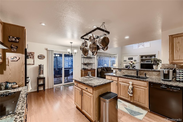 kitchen with sink, a chandelier, a kitchen island, black appliances, and light wood-type flooring