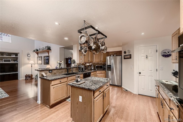 kitchen featuring sink, stainless steel fridge with ice dispenser, kitchen peninsula, a kitchen island, and light wood-type flooring