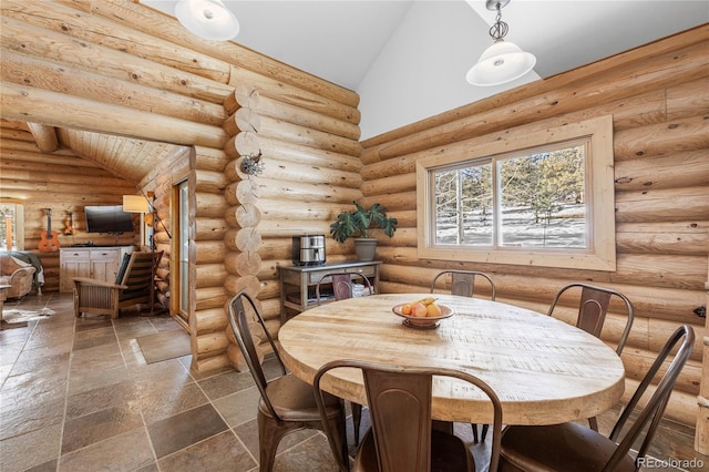 dining space with rustic walls and high vaulted ceiling