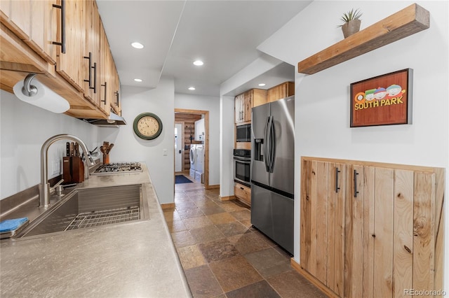 kitchen with stainless steel appliances, separate washer and dryer, and sink