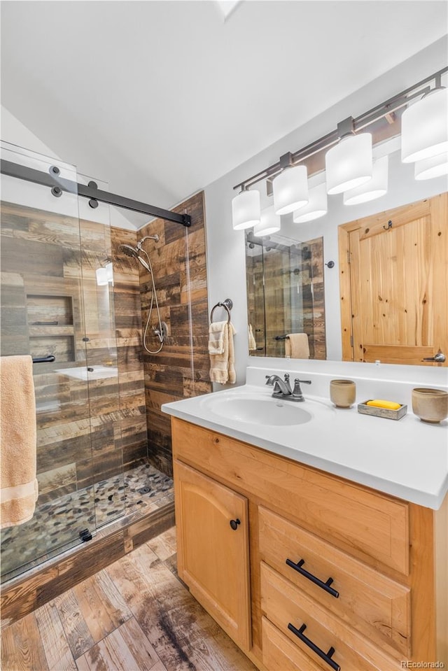 bathroom with hardwood / wood-style flooring, vanity, and an enclosed shower