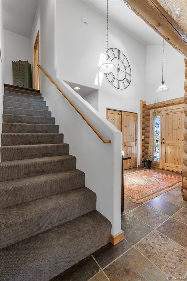 stairs with rustic walls and high vaulted ceiling