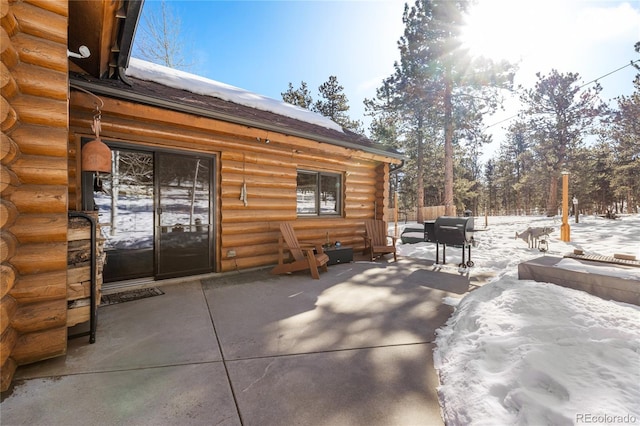 snow covered patio with a grill