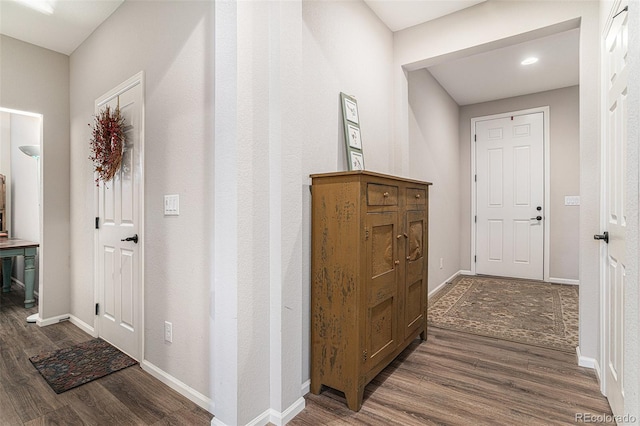 hallway with dark wood finished floors and baseboards