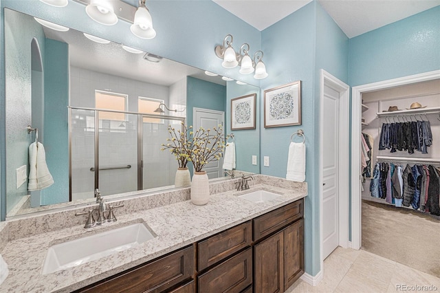 13942 W 87th Dr, Arvada, CO 80005 - bathroom with double vanity, a stall shower, and a spacious closet