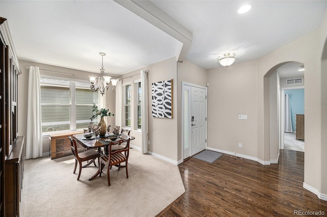 13942 W 87th Dr, Arvada, CO 80005 - dining space featuring arched walkways, a chandelier, baseboards, and wood finished floors
