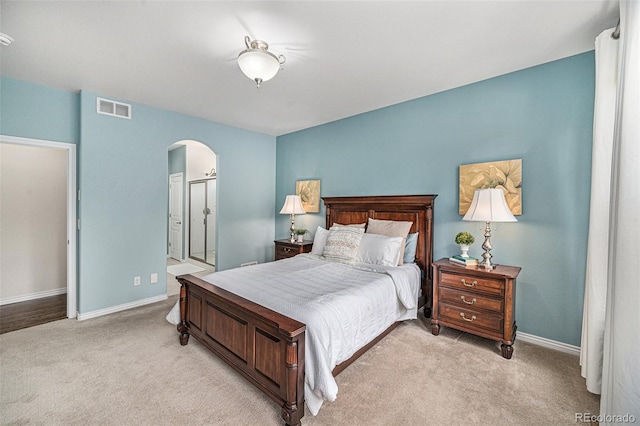 13942 W 87th Dr, Arvada, CO 80005 - bedroom featuring arched walkways, light colored carpet, baseboards, and ensuite bathroom