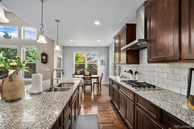 13942 W 87th Dr, Arvada, CO 80005 - kitchen featuring a sink, wall chimney range hood, stainless steel gas cooktop, dark wood-type flooring, and tasteful backsplash