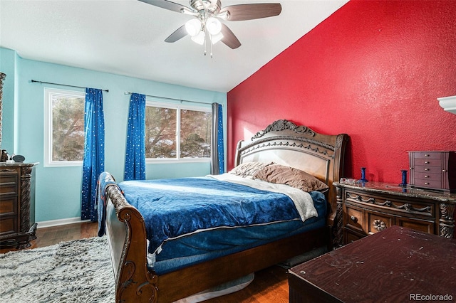 bedroom with lofted ceiling, multiple windows, ceiling fan, and hardwood / wood-style floors