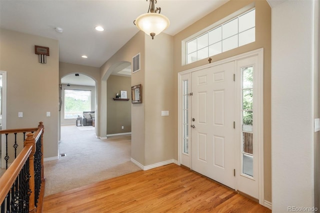 2105 Baguette Dr, Castle Rock, CO 80108 - entrance foyer with arched walkways, light wood-type flooring, recessed lighting, and light carpet
