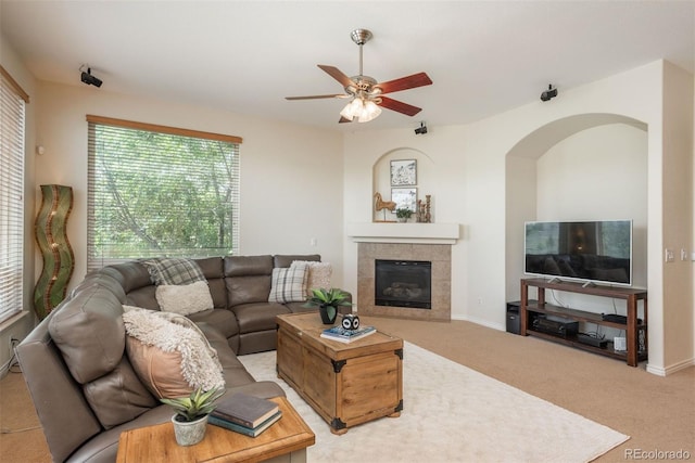 2105 Baguette Dr, Castle Rock, CO 80108 - carpeted living area featuring a ceiling fan, a tile fireplace, and arched walkways