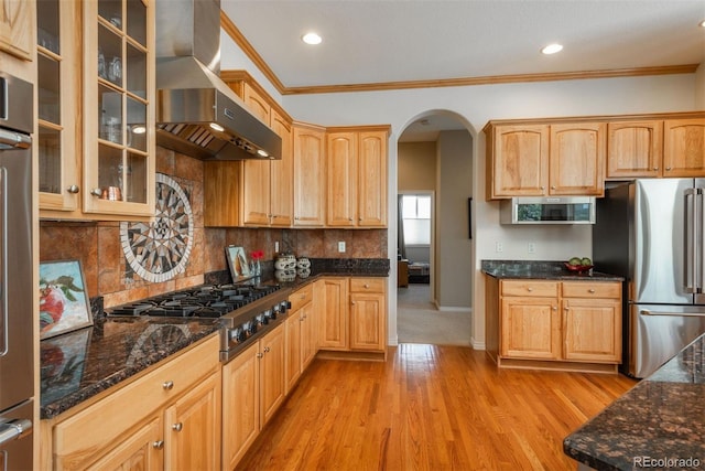 2105 Baguette Dr, Castle Rock, CO 80108 - kitchen with appliances with stainless steel finishes, wall chimney range hood, arched walkways, light wood-style flooring, and ornamental molding
