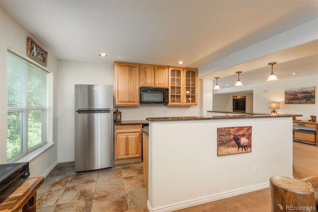 2105 Baguette Dr, Castle Rock, CO 80108 - kitchen with freestanding refrigerator, black microwave, dark countertops, glass insert cabinets, and light stone finish flooring