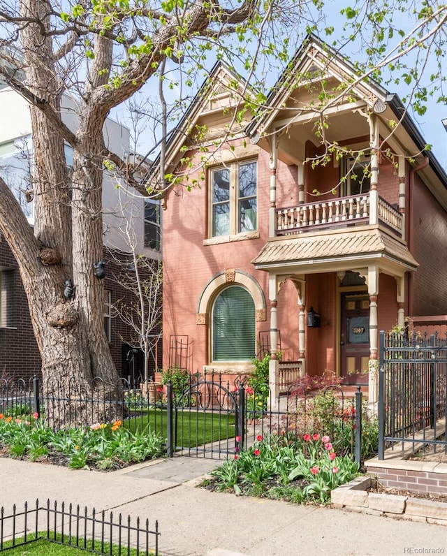 3147 Vallejo St, Denver, CO 80211 - victorian house with a balcony, brick siding, and a fenced front yard