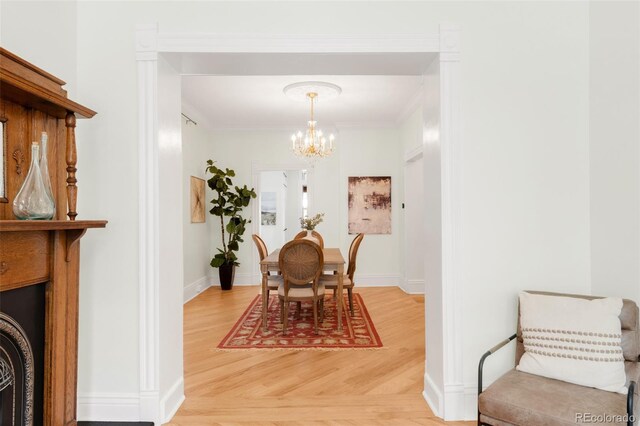 3147 Vallejo St, Denver, CO 80211 - dining space featuring a chandelier, baseboards, light wood-type flooring, and ornamental molding