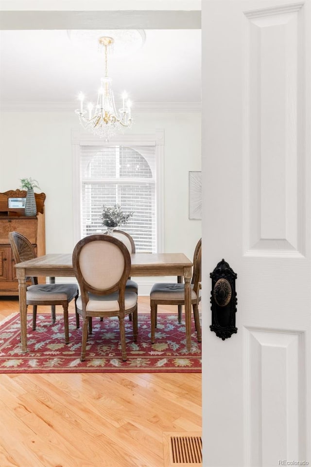 3147 Vallejo St, Denver, CO 80211 - dining area featuring a chandelier, ornamental molding, and light wood finished floors