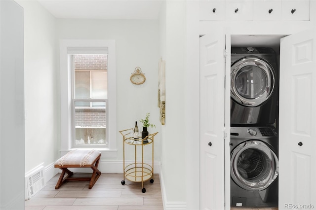 3147 Vallejo St, Denver, CO 80211 - washroom featuring stacked washer and clothes dryer, baseboards, and wood finish floors