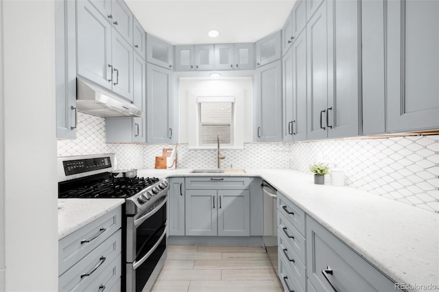 3147 Vallejo St, Denver, CO 80211 - kitchen with double oven range, under cabinet range hood, a sink, glass insert cabinets, and decorative backsplash