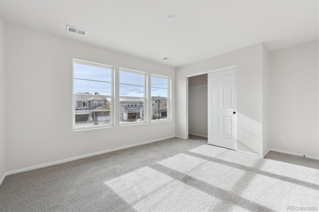 unfurnished bedroom featuring light colored carpet and a closet