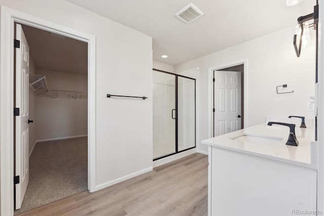 bathroom featuring vanity, hardwood / wood-style floors, and a shower with shower door