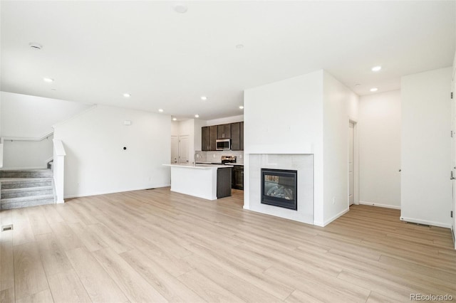 13568 E 111th Ave, Commerce City, CO 80022 - unfurnished living room with stairway, recessed lighting, light wood finished floors, and a tile fireplace