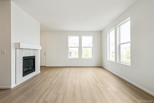 13568 E 111th Ave, Commerce City, CO 80022 - unfurnished living room featuring light wood-type flooring and a tiled fireplace