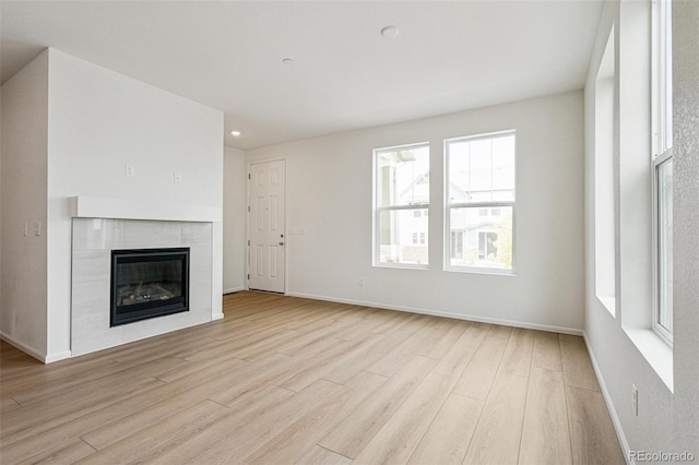 13568 E 111th Ave, Commerce City, CO 80022 - unfurnished living room featuring light wood finished floors, a tile fireplace, and recessed lighting