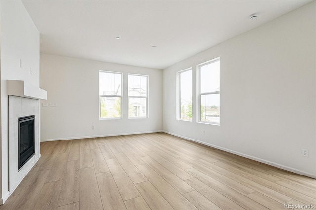 13568 E 111th Ave, Commerce City, CO 80022 - unfurnished living room featuring light wood-style flooring and a tile fireplace