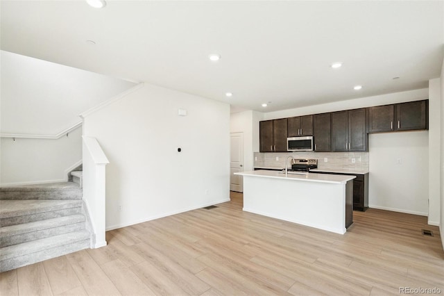 13568 E 111th Ave, Commerce City, CO 80022 - kitchen featuring tasteful backsplash, light countertops, recessed lighting, a center island with sink, and stainless steel appliances