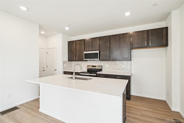 13568 E 111th Ave, Commerce City, CO 80022 - kitchen featuring appliances with stainless steel finishes, light wood-type flooring, backsplash, dark brown cabinets, and light countertops