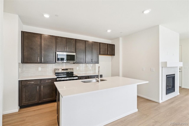 13568 E 111th Ave, Commerce City, CO 80022 - kitchen featuring light wood finished floors, stainless steel appliances, decorative backsplash, dark brown cabinetry, and light countertops