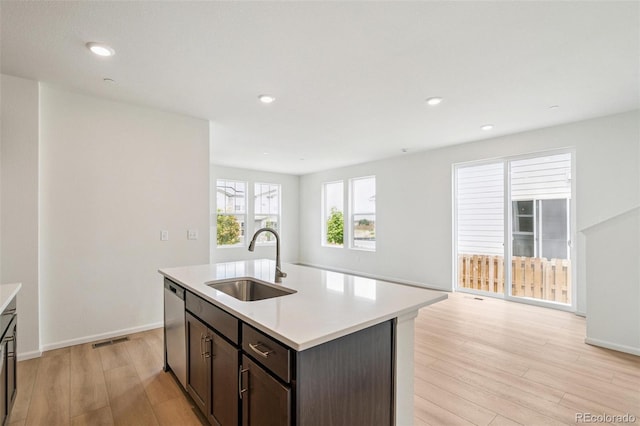13568 E 111th Ave, Commerce City, CO 80022 - kitchen featuring light wood finished floors, light countertops, open floor plan, stainless steel dishwasher, and an island with sink