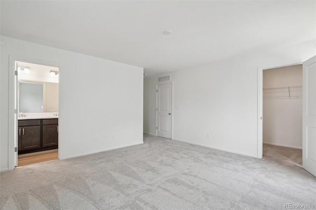 13568 E 111th Ave, Commerce City, CO 80022 - unfurnished bedroom featuring light carpet, a spacious closet, and ensuite bath