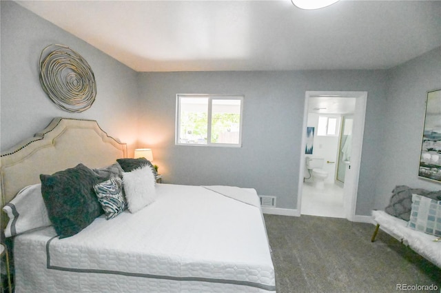 bedroom with baseboards, multiple windows, ensuite bath, and carpet floors