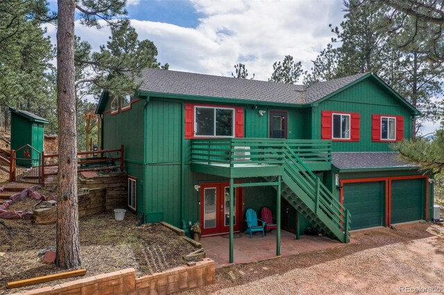 517 Crystal Peak Rd, Florissant, CO 80816 - rustic home with a shingled roof, stairs, a deck, an attached garage, and driveway