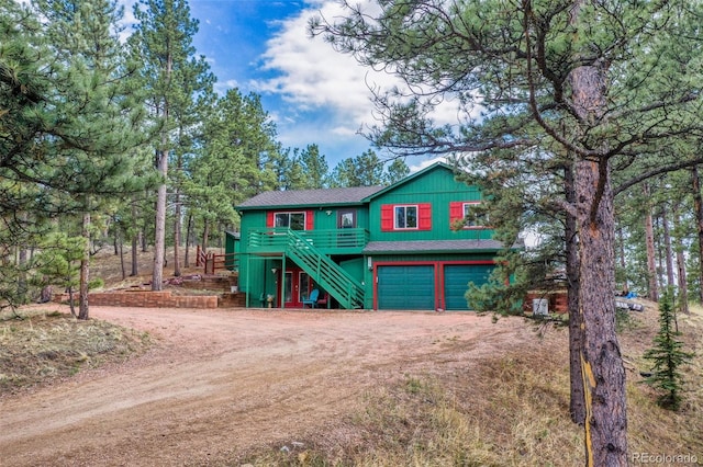 517 Crystal Peak Rd, Florissant, CO 80816 - view of front facade with stairway, driveway, an attached garage, and a shingled roof