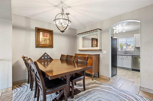 1522 Chimney Peak Dr, Castle Rock, CO 80109 - dining room featuring a chandelier, arched walkways, light tile patterned floors, and baseboards