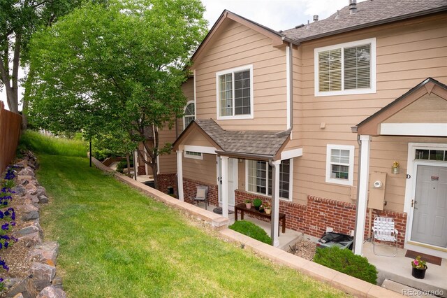 6845 S Webster St Unit E, Littleton, CO 80128 - view of front facade featuring brick siding, a front lawn, and a shingled roof