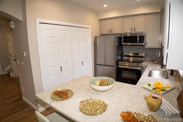 6845 S Webster St Unit E, Littleton, CO 80128 - kitchen with stainless steel appliances, arched walkways, light stone countertops, backsplash, and dark wood-type flooring