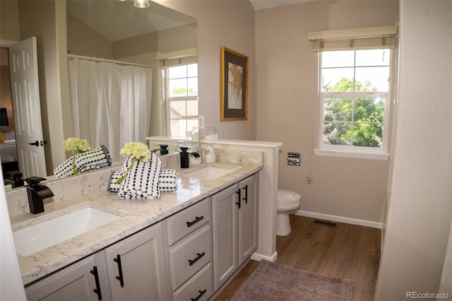 6845 S Webster St Unit E, Littleton, CO 80128 - bathroom featuring double vanity, wood finished floors, and curtained shower