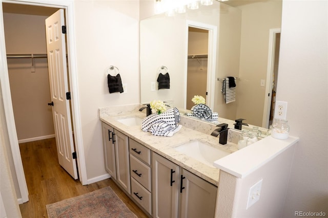 6845 S Webster St Unit E, Littleton, CO 80128 - bathroom featuring double vanity, wood finished floors, and a walk in closet