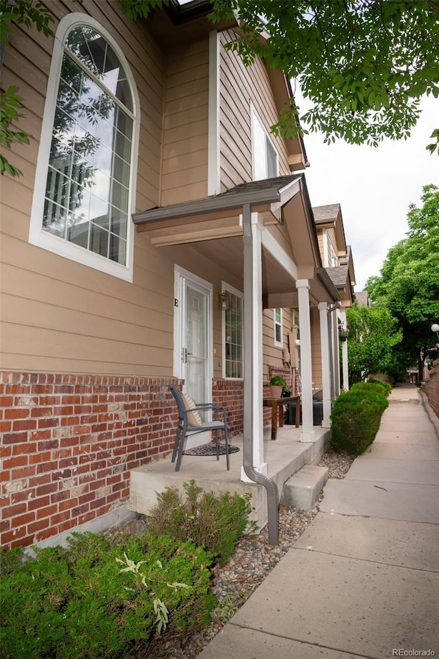 6845 S Webster St Unit E, Littleton, CO 80128 - property entrance featuring covered porch and brick siding