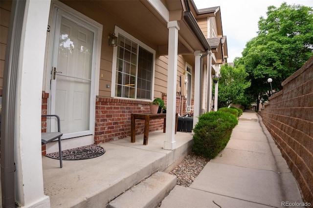 6845 S Webster St Unit E, Littleton, CO 80128 - view of exterior entry with a porch and brick siding