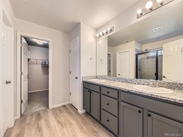 917 White Leaf Cir, Castle Rock, CO 80108 - full bath with a stall shower, wood finished floors, double vanity, a spacious closet, and baseboards