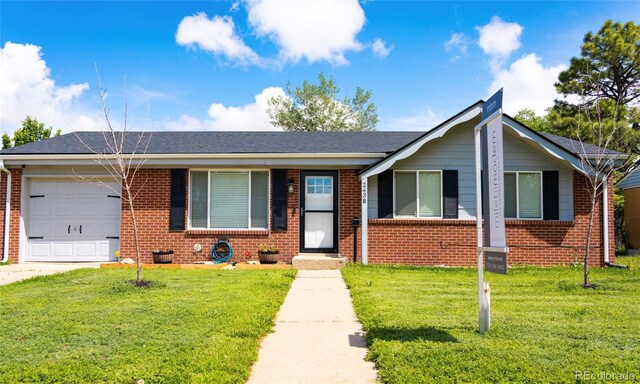 2438 W 24th Street Rd, Greeley, CO 80634 - view of front of house with a garage, brick siding, and a front lawn