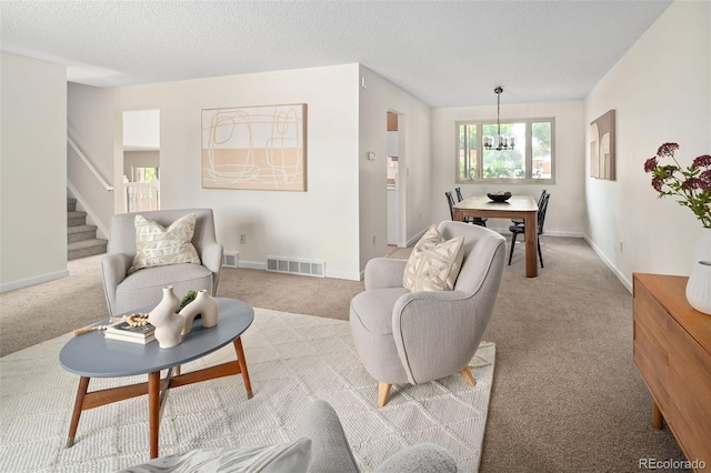 6463 S Vance St, Littleton, CO 80123 - living area featuring light carpet, stairway, a chandelier, and a textured ceiling