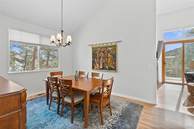 dining space featuring a wealth of natural light, a notable chandelier, and wood finished floors