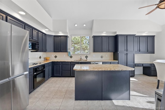 kitchen with light tile patterned floors, backsplash, a sink, a kitchen island, and black appliances