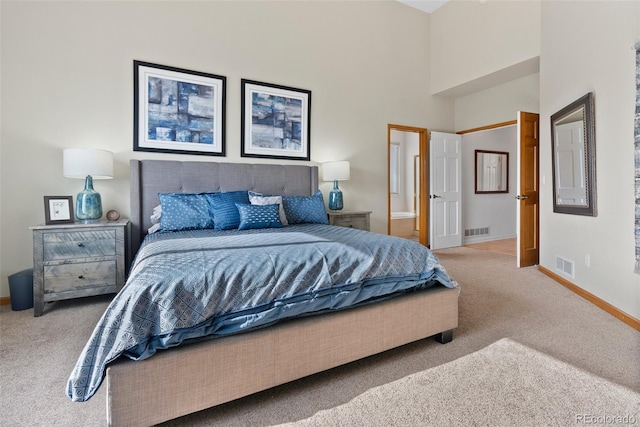 bedroom featuring baseboards, visible vents, carpet flooring, and ensuite bathroom