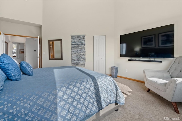 bedroom with carpet floors, a high ceiling, and baseboards